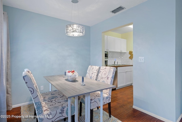 dining room featuring dark wood-type flooring and sink