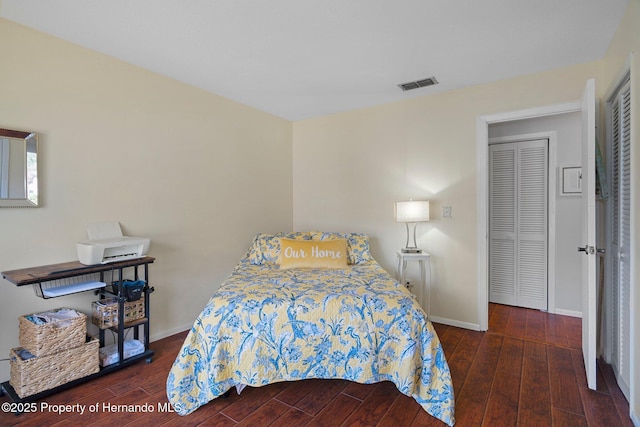 bedroom featuring dark wood-type flooring and a closet