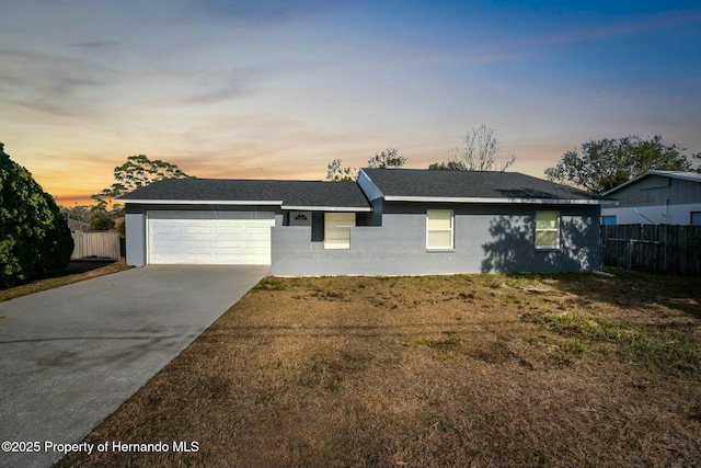 single story home with a garage and a lawn