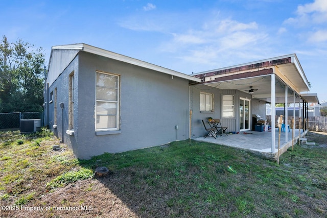 back of property featuring cooling unit, a yard, a patio, and ceiling fan