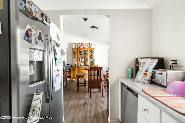 kitchen featuring appliances with stainless steel finishes, hardwood / wood-style floors, and white cabinets