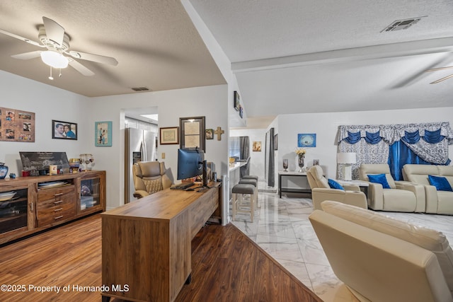 home office with vaulted ceiling with beams, a textured ceiling, and ceiling fan