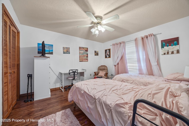 bedroom with ceiling fan, dark wood-type flooring, a textured ceiling, and a closet