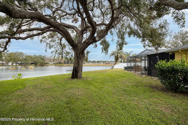 view of yard featuring a water view and glass enclosure