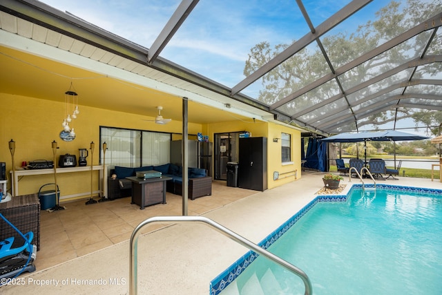 view of pool with a lanai, a patio area, outdoor lounge area, and ceiling fan