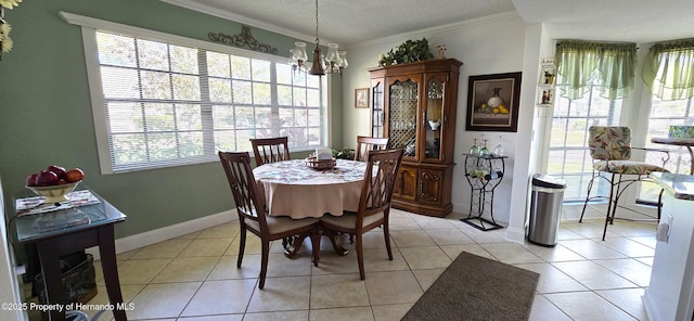 tiled dining room with ornamental molding, a chandelier, and a textured ceiling