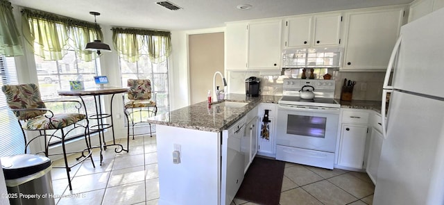 kitchen featuring pendant lighting, sink, white appliances, white cabinetry, and kitchen peninsula