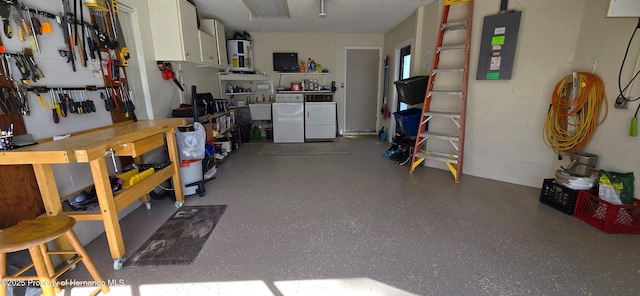 garage featuring water heater, electric panel, and a workshop area