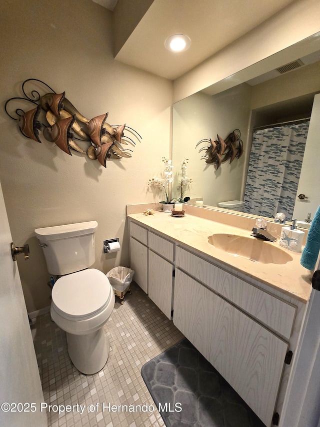 bathroom with tile patterned flooring, vanity, and toilet