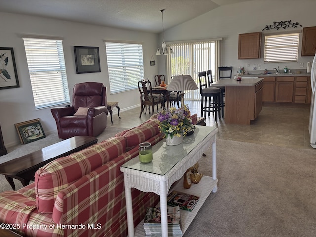 living area with lofted ceiling, light tile patterned flooring, light colored carpet, and a healthy amount of sunlight