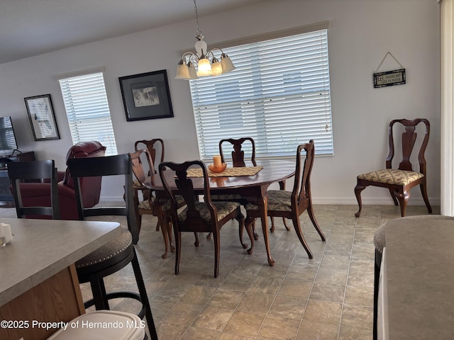 dining area with a chandelier and baseboards