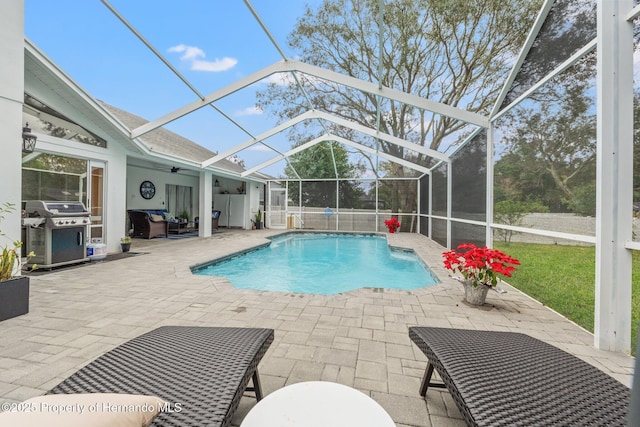 view of swimming pool featuring a patio, a grill, ceiling fan, and glass enclosure