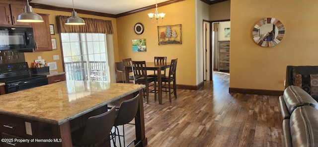 kitchen featuring pendant lighting, dark hardwood / wood-style flooring, a center island, black appliances, and crown molding