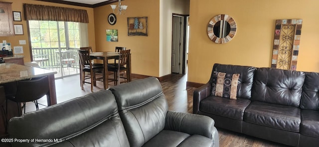 living room with an inviting chandelier, ornamental molding, and hardwood / wood-style floors