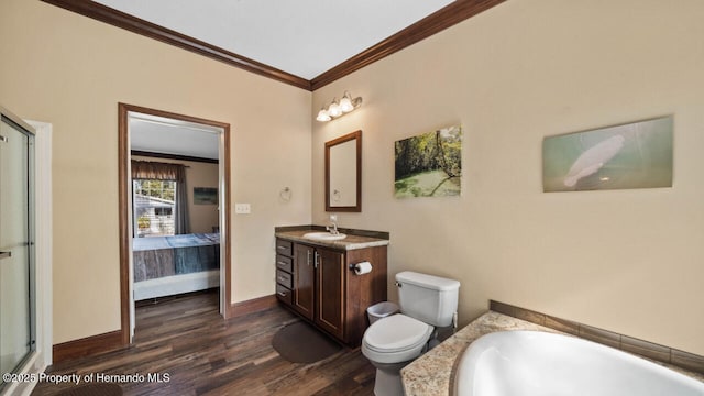 bathroom featuring vanity, wood-type flooring, ornamental molding, a tub to relax in, and toilet