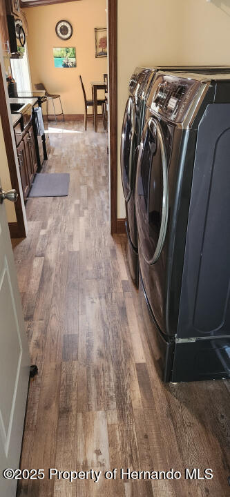 laundry area with washing machine and clothes dryer and dark hardwood / wood-style floors