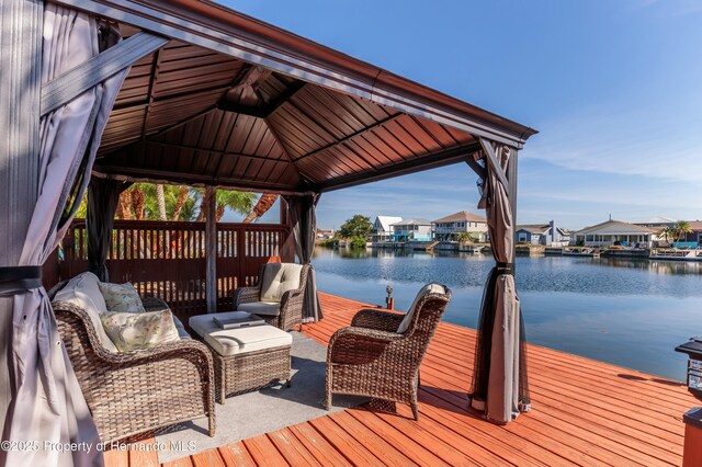 dock area with a water view, an outdoor hangout area, and a gazebo