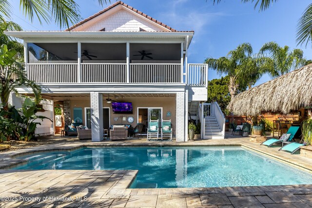 rear view of house featuring ceiling fan, an outdoor living space, stairs, a patio area, and a tile roof