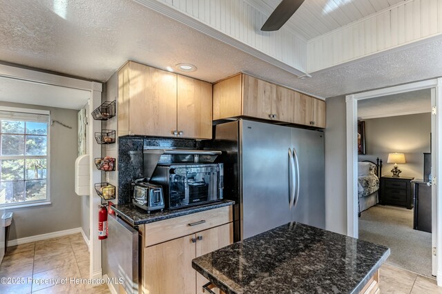 kitchen featuring freestanding refrigerator, a ceiling fan, baseboards, and light brown cabinets