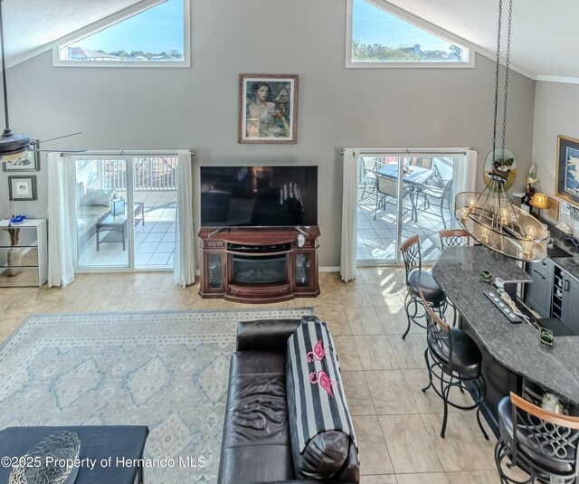 living area featuring ornamental molding, a wealth of natural light, and high vaulted ceiling