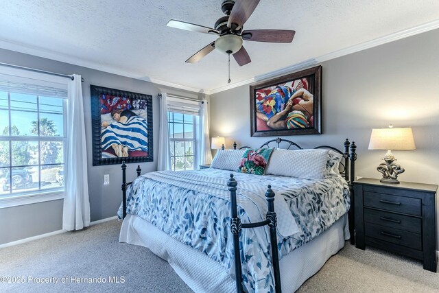 bedroom with a ceiling fan, a textured ceiling, baseboards, ornamental molding, and light carpet