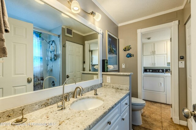 full bathroom featuring vanity, toilet, ornamental molding, tiled shower, and washer and dryer