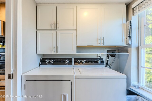 laundry room with cabinet space and washer and clothes dryer