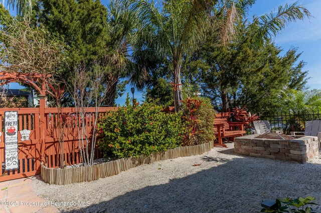 view of yard with a fire pit and fence