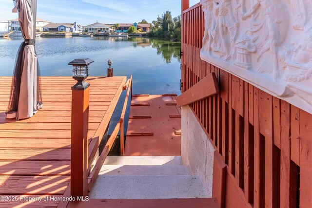 view of dock with a water view and a residential view