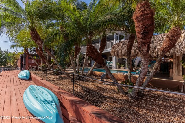 exterior space featuring fence, a wooden deck, and an outdoor pool