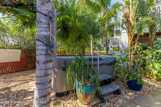 exterior space with a hot tub and fence
