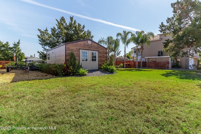 view of yard with fence and an outdoor structure