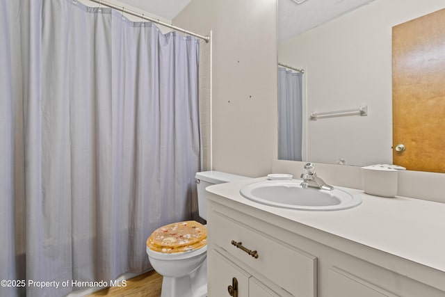 bathroom featuring a shower with curtain, vanity, and toilet