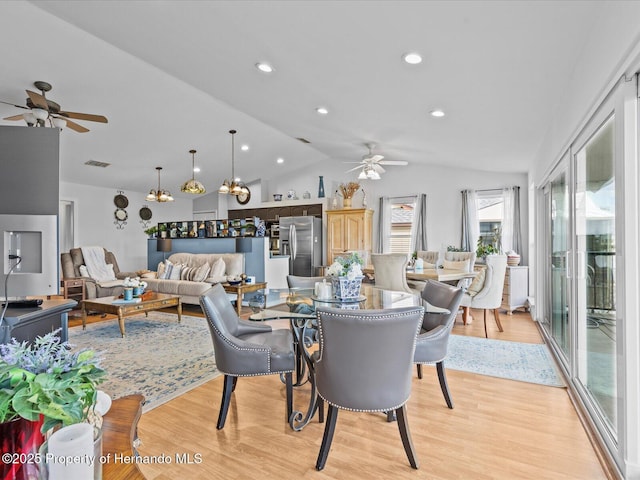 dining room featuring lofted ceiling, ceiling fan, and light hardwood / wood-style flooring