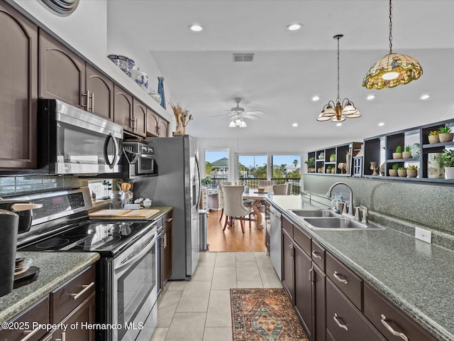 kitchen featuring appliances with stainless steel finishes, sink, dark brown cabinets, and light tile patterned floors