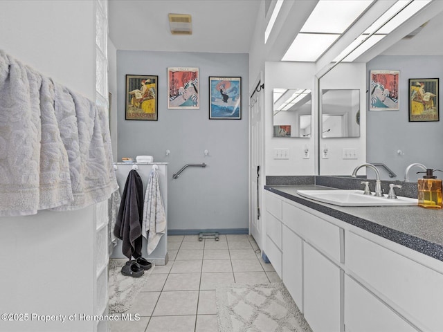 bathroom featuring tile patterned flooring, vanity, and a skylight