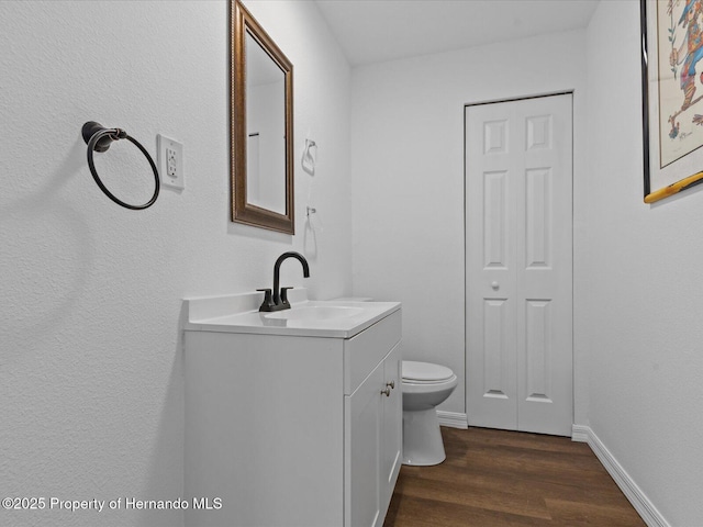 bathroom featuring vanity, wood-type flooring, and toilet