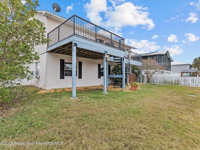 back of property featuring a wooden deck and a yard