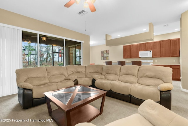 living room featuring ceiling fan, recessed lighting, visible vents, and light colored carpet