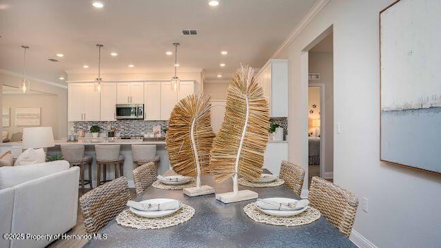 dining space featuring crown molding