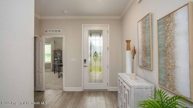 doorway featuring ornamental molding and light wood-type flooring