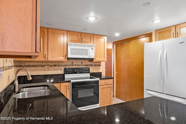 kitchen featuring tasteful backsplash, white appliances, dark stone counters, and sink