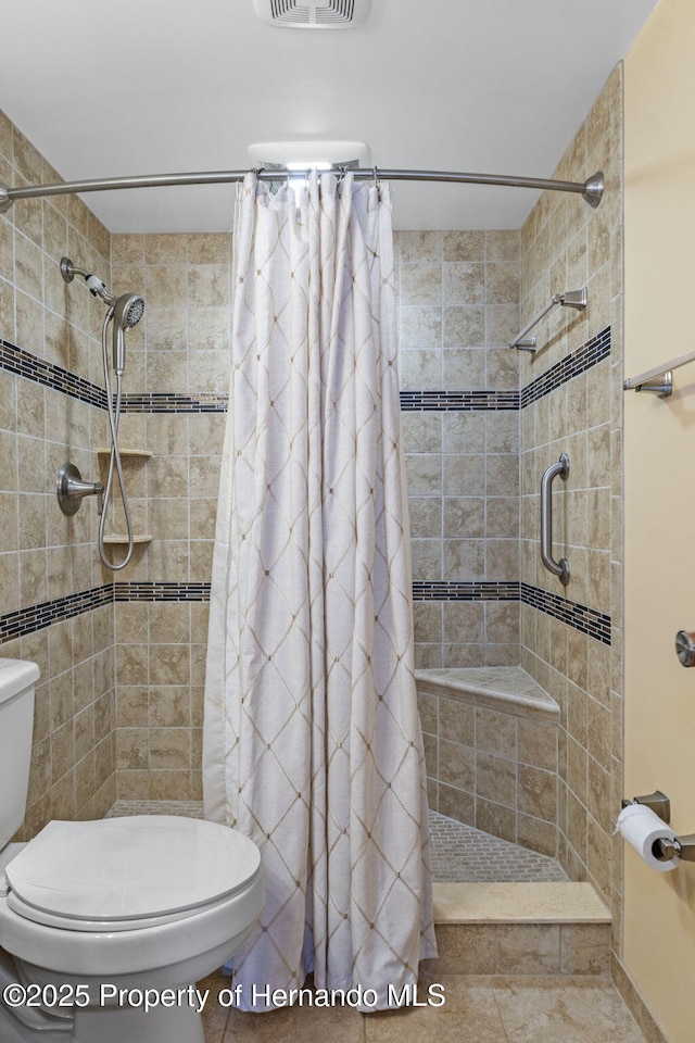 bathroom with toilet and a shower with shower curtain