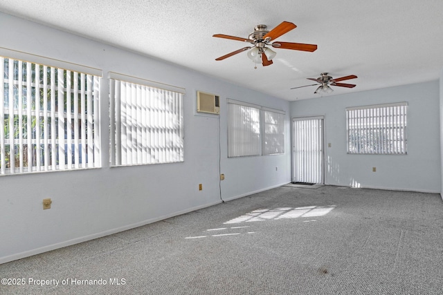 carpeted empty room featuring a wall mounted AC and a textured ceiling