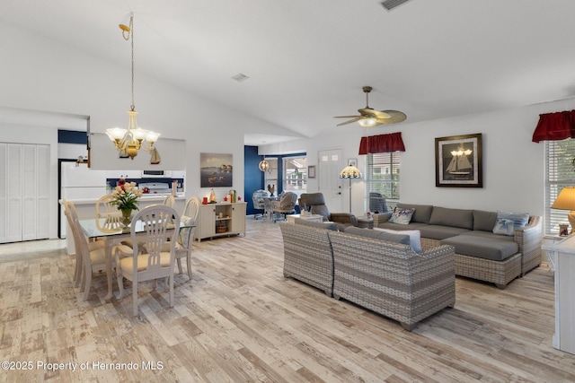 living room featuring high vaulted ceiling, ceiling fan with notable chandelier, and light hardwood / wood-style flooring