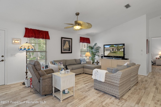 living room with vaulted ceiling, ceiling fan, and light wood-type flooring