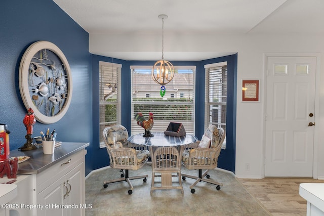 dining area with a notable chandelier and light hardwood / wood-style flooring