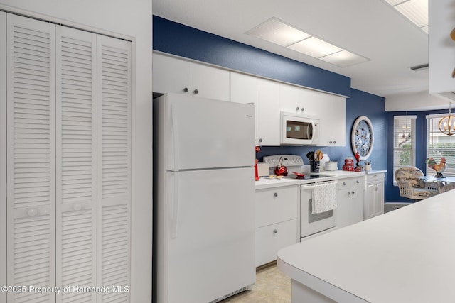 kitchen with white cabinetry and white appliances