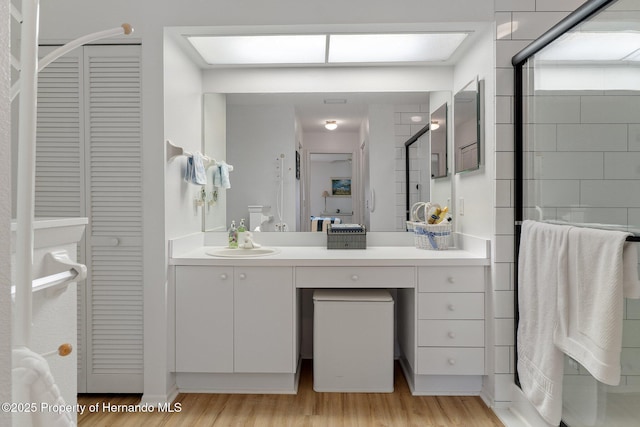 bathroom featuring a shower with door, vanity, and hardwood / wood-style floors