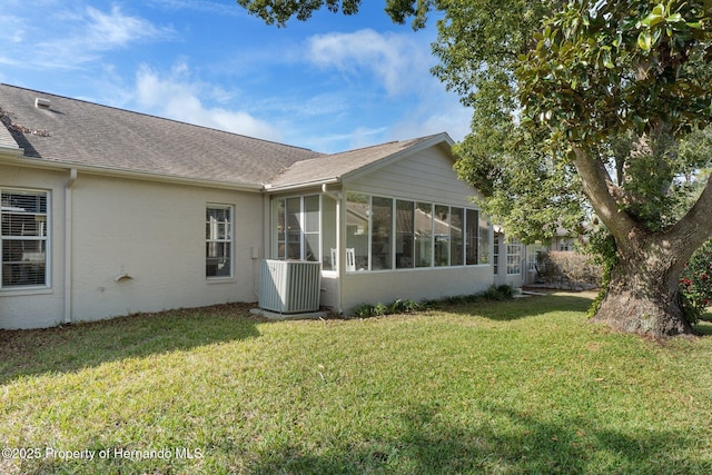 view of home's exterior with a yard, a sunroom, and central air condition unit